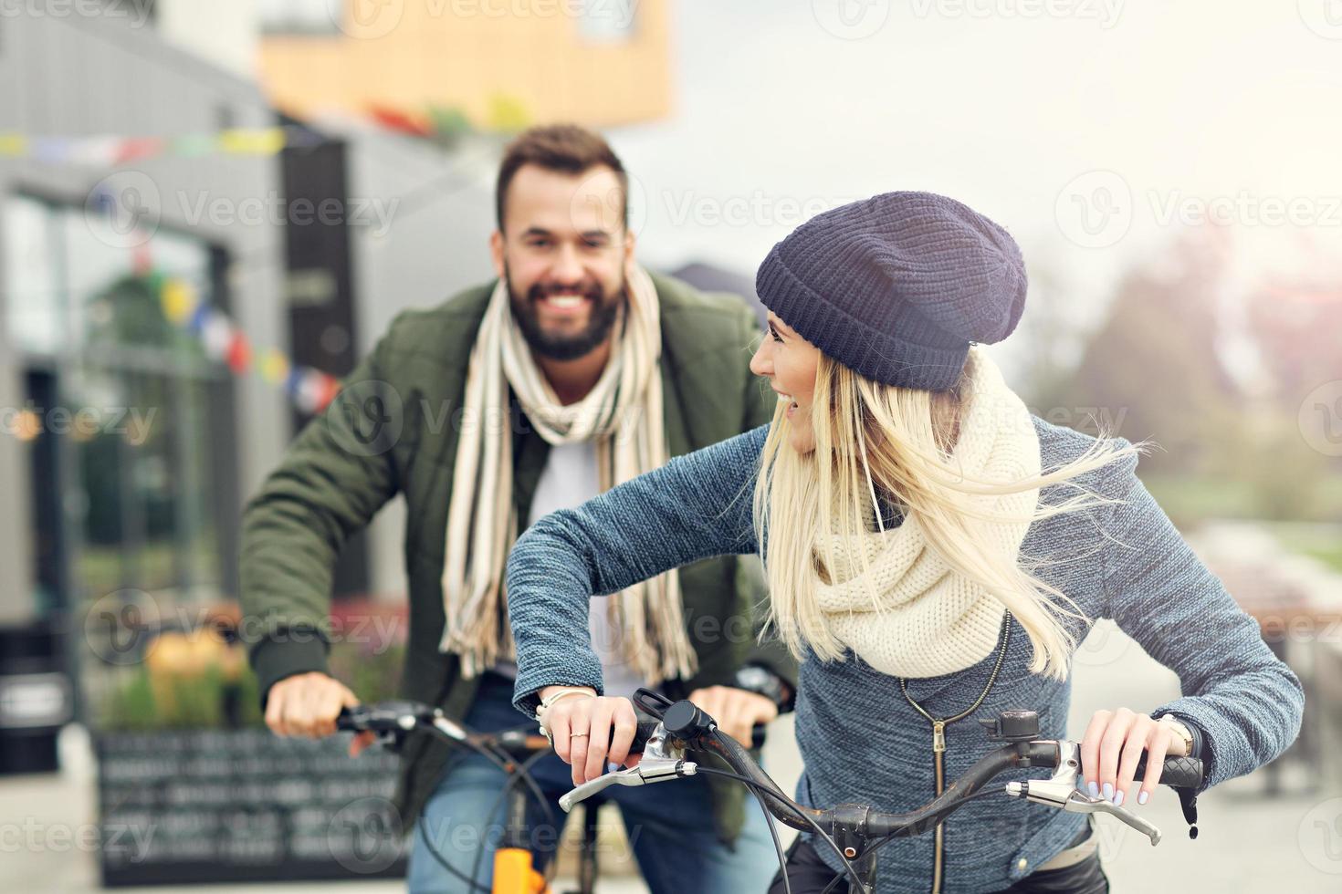 Young couple riding bikes and having fun in the city photo