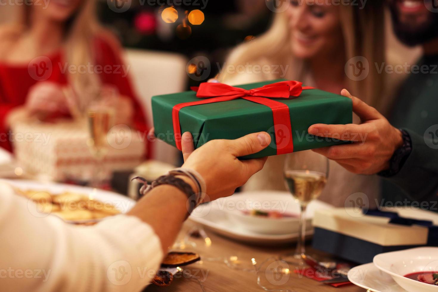 Group of friends giving Christmas presents at home photo
