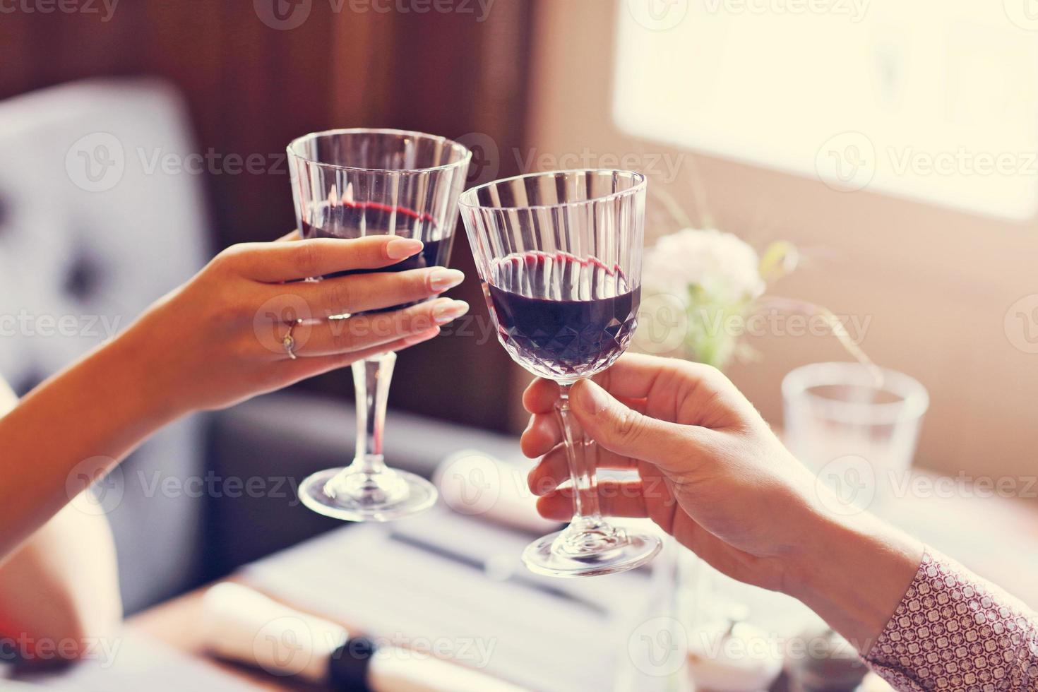 Couple eating romantic Dinner in a gourmet restaurant drinking wine and holding hands photo