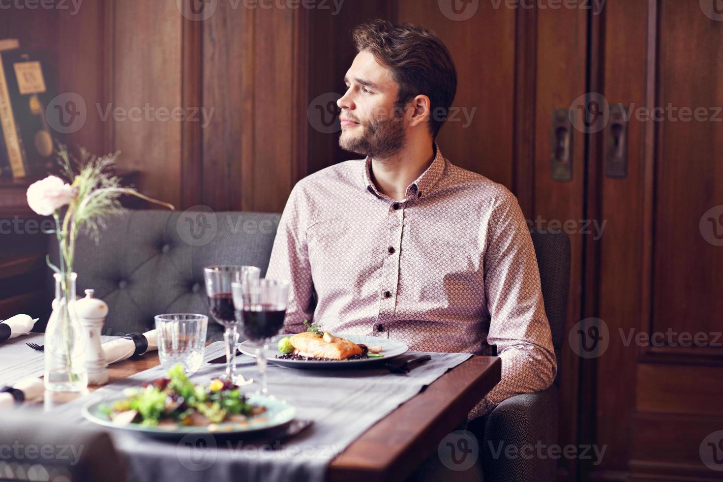 Handsome man waiting at table in restaurant photo