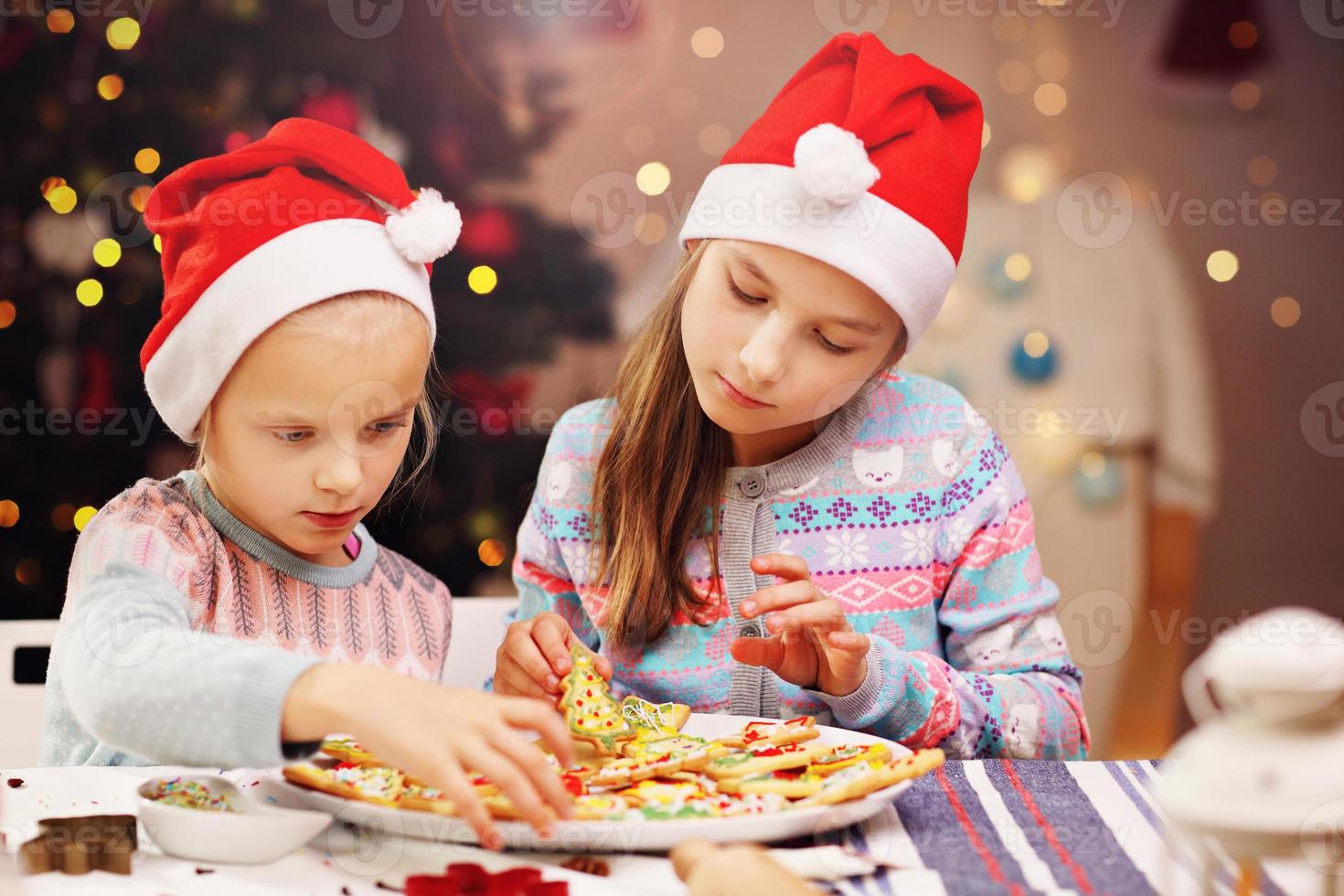 Happy little sisters preparing Christmas biscuits photo