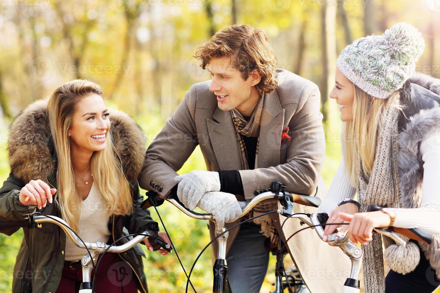 Group of friends on bikes in forest during fall time photo