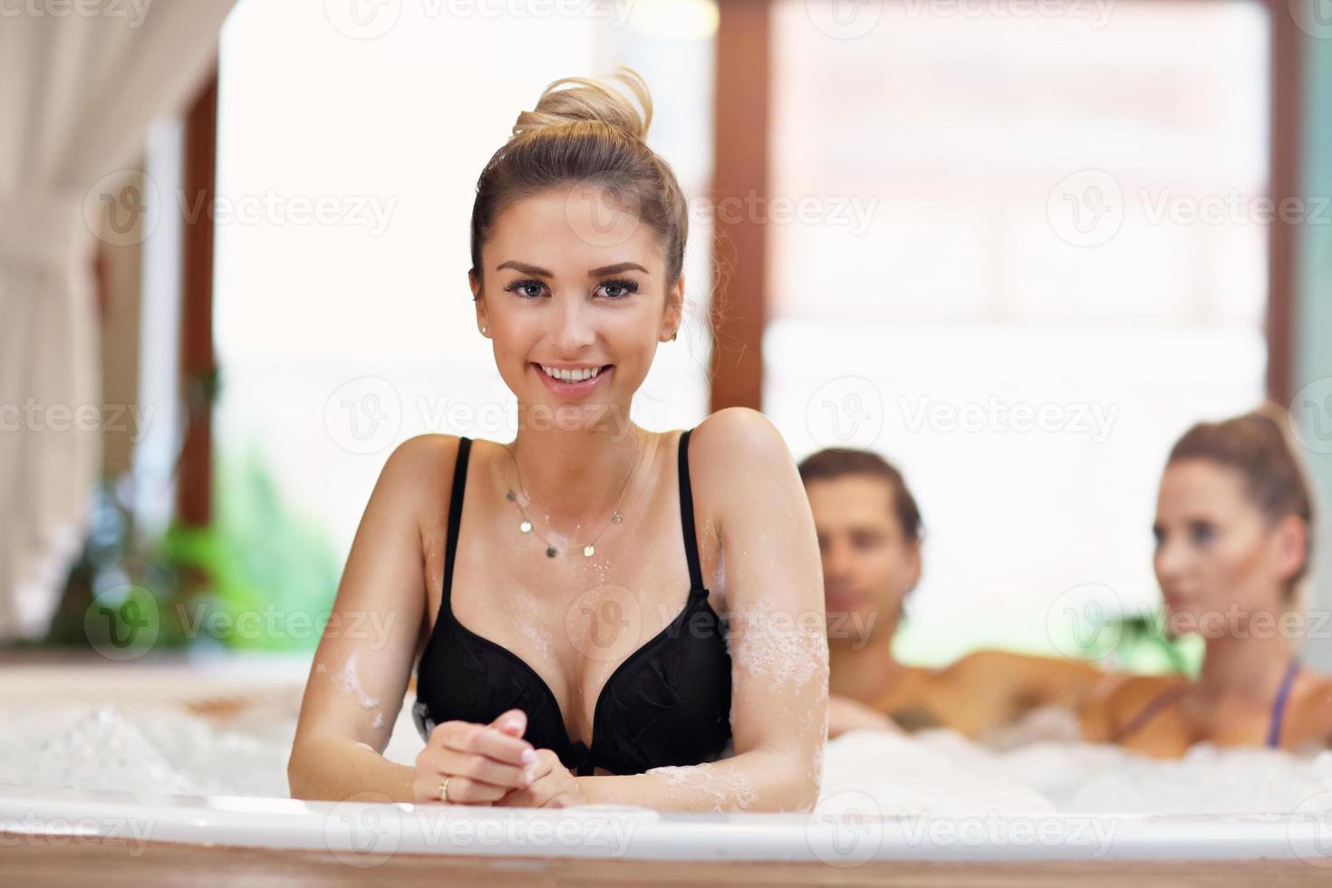 Group of friends enjoying jacuzzi in hotel spa photo