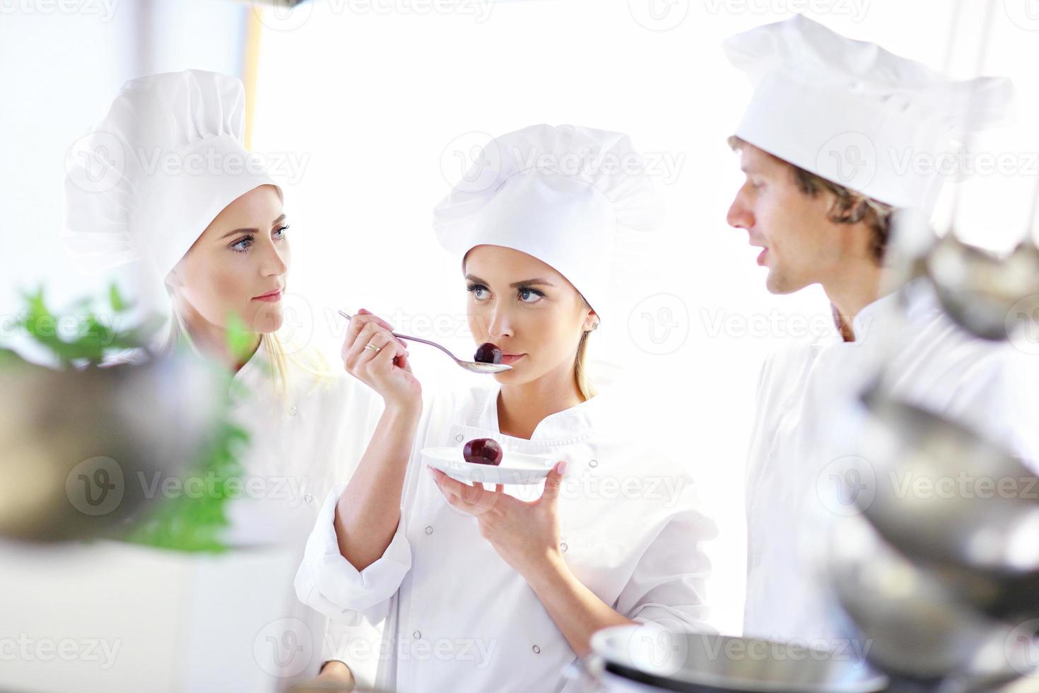 Busy chefs at work in the restaurant kitchen photo