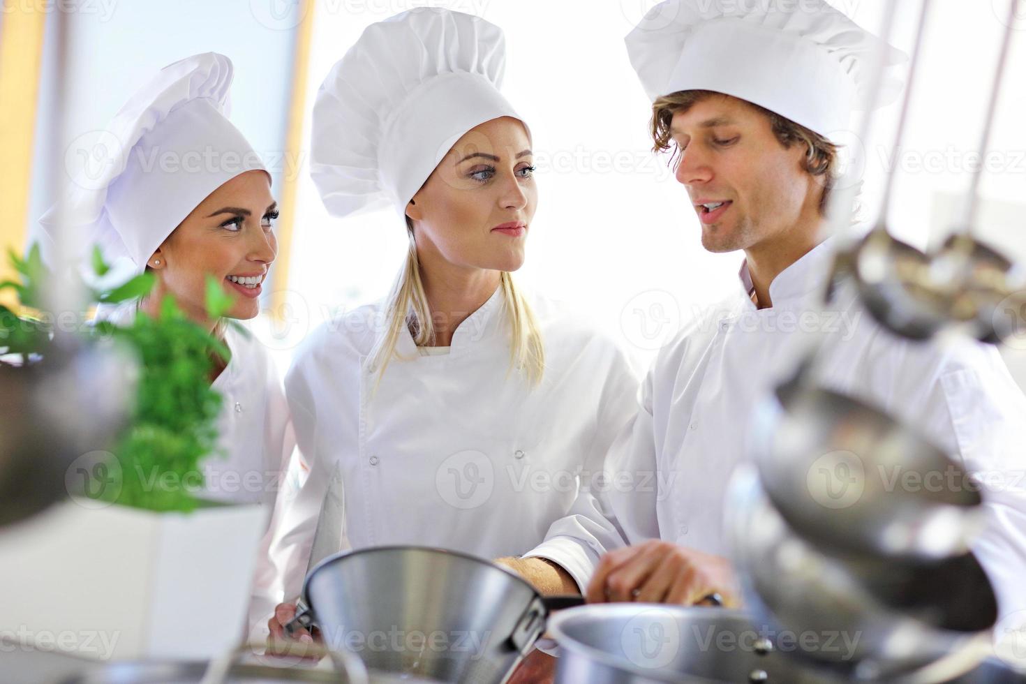 Busy chefs at work in the restaurant kitchen photo
