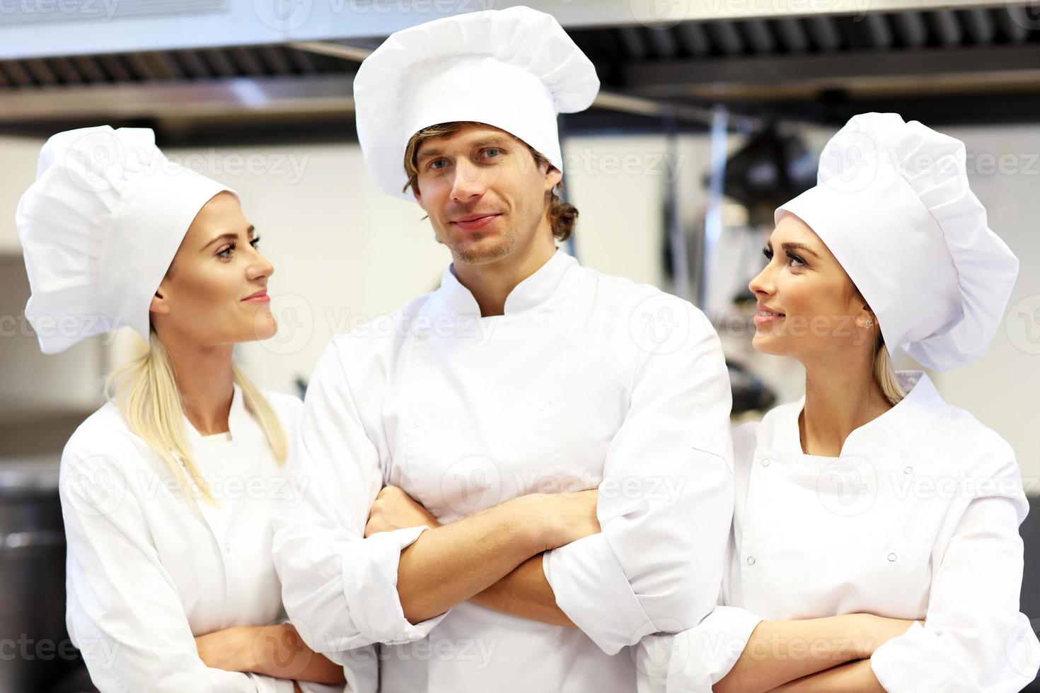 Busy chefs at work in the restaurant kitchen photo