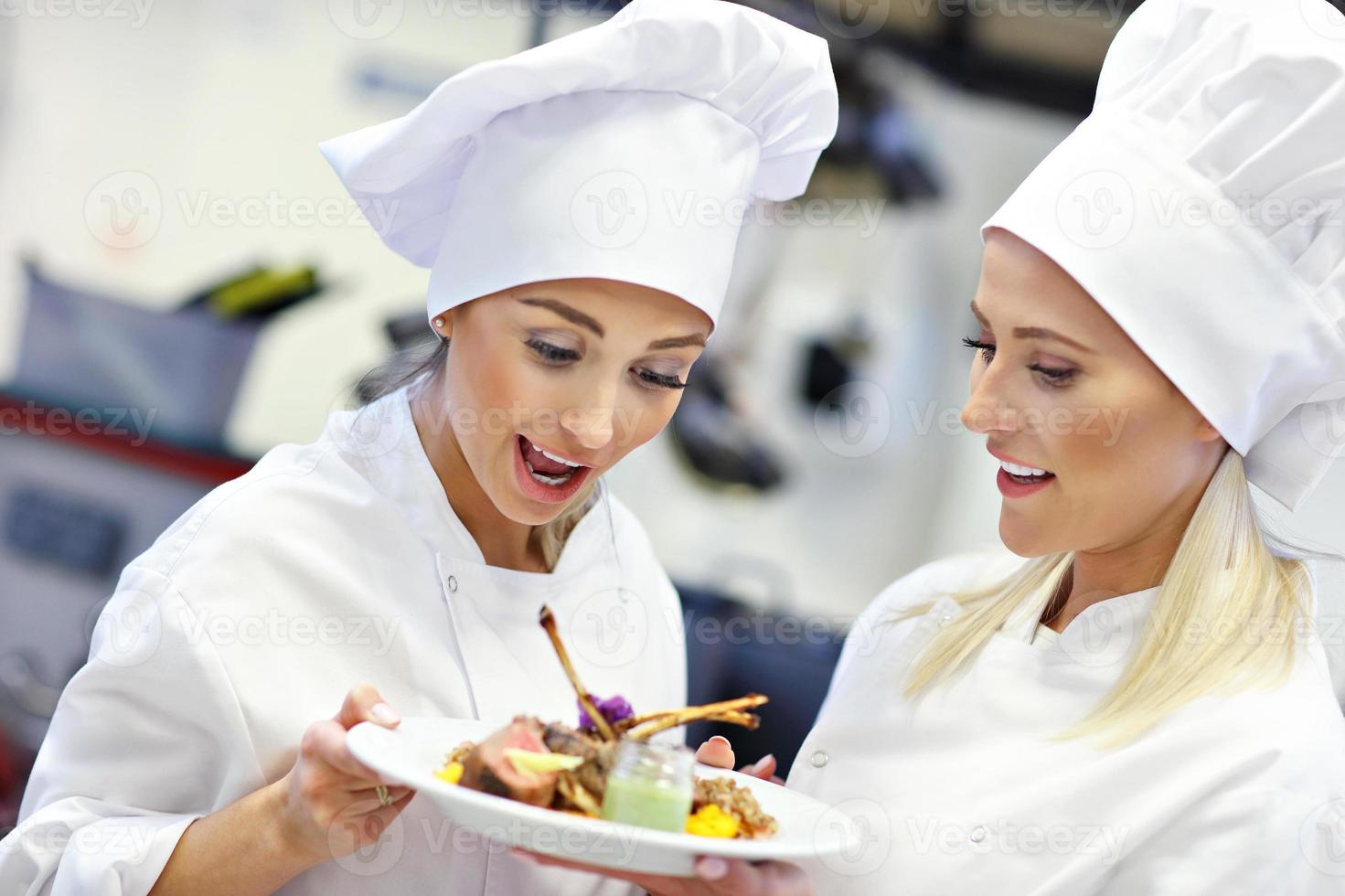Busy chefs at work in the restaurant kitchen photo