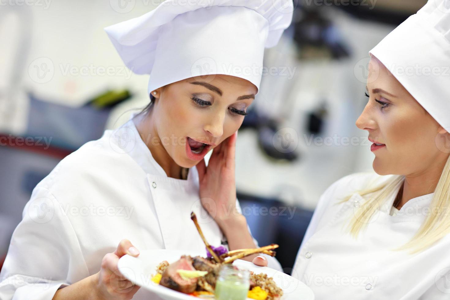 Busy chefs at work in the restaurant kitchen photo