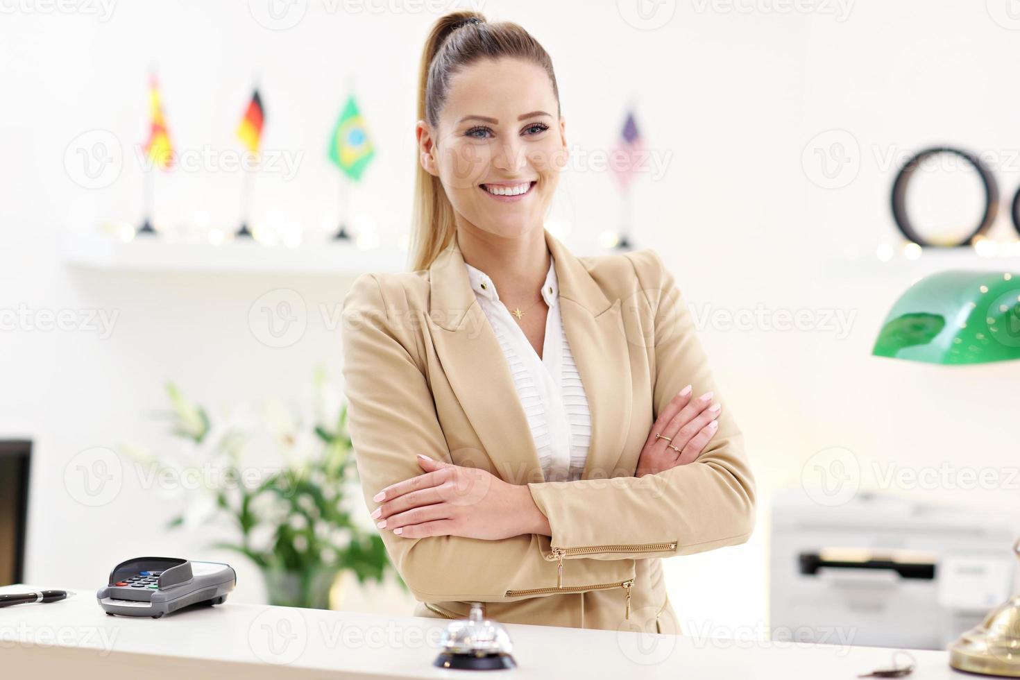 Happy receptionist working in hotel photo