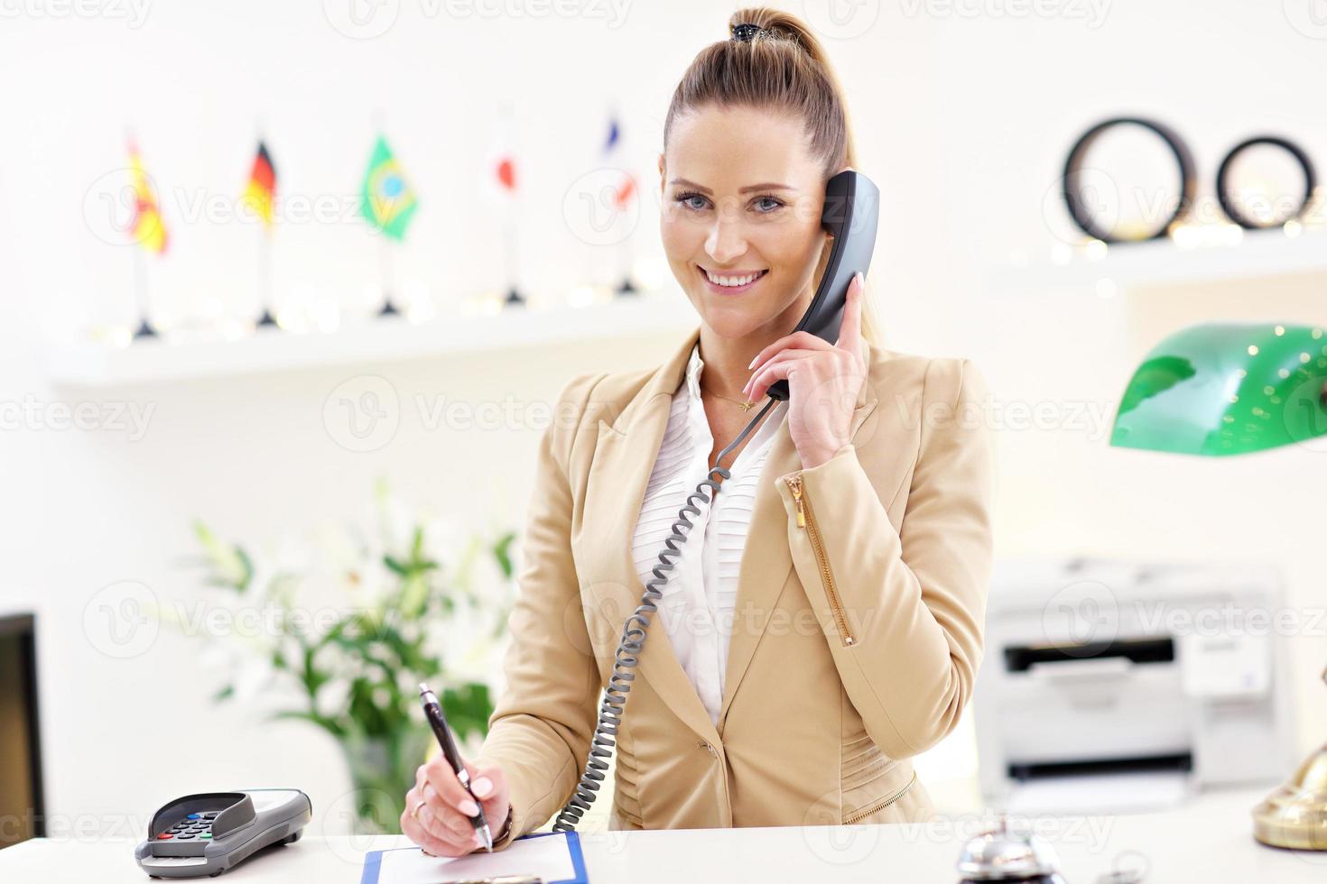 Happy receptionist working in hotel photo