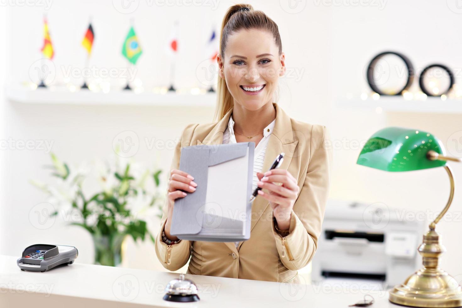 Happy receptionist working in hotel photo