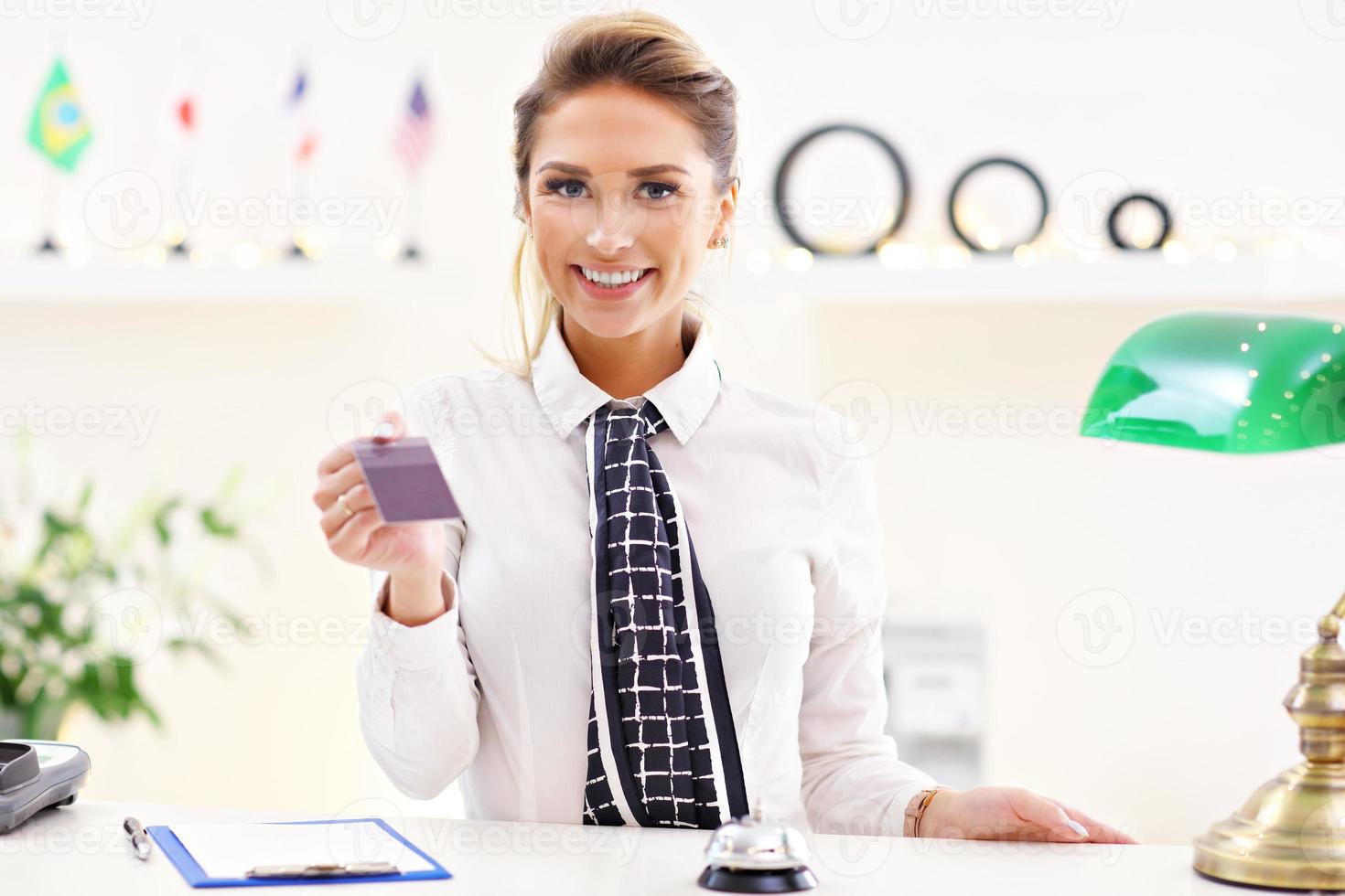 Happy receptionist working in hotel photo