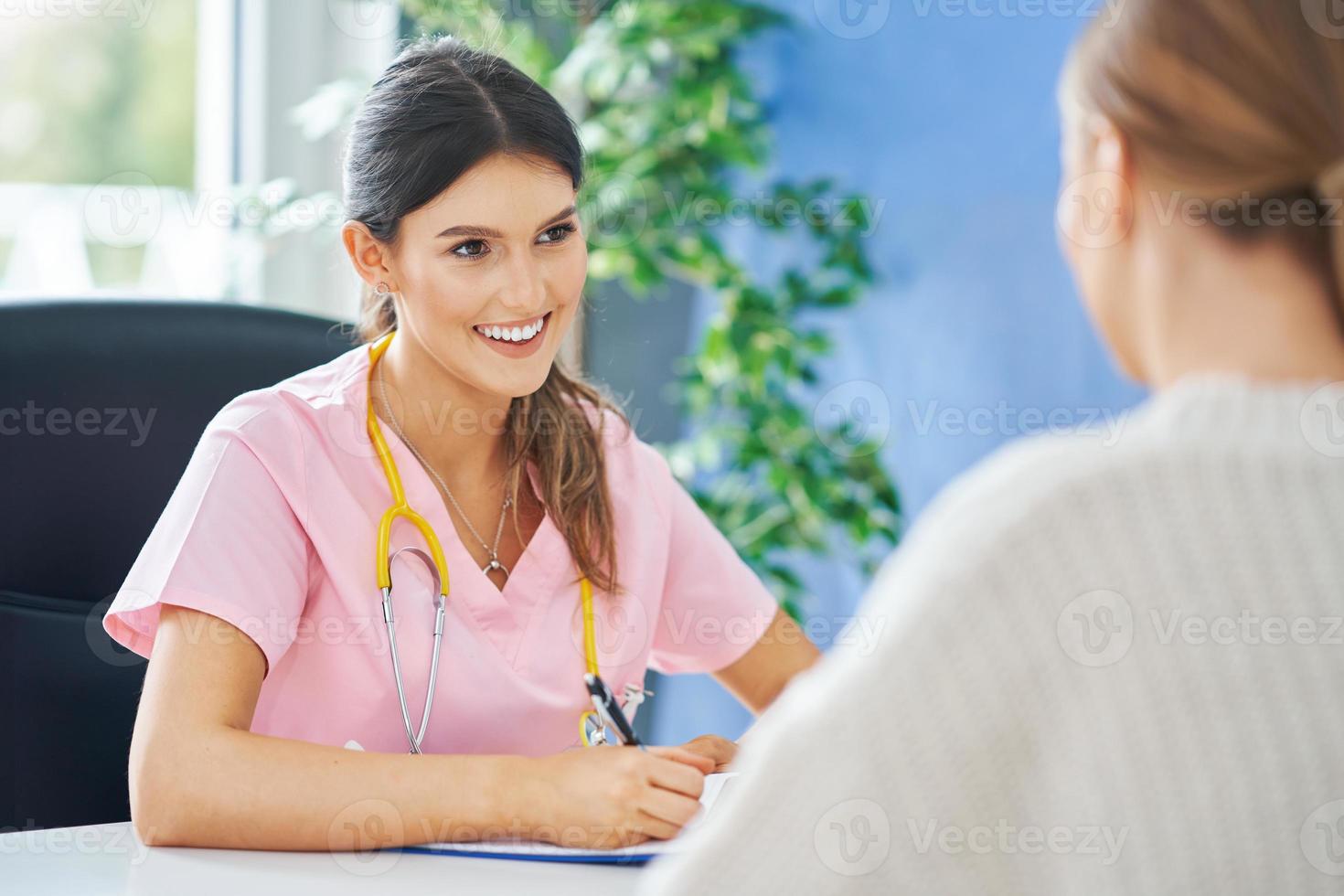 Doctor explaining diagnosis to her female patient photo