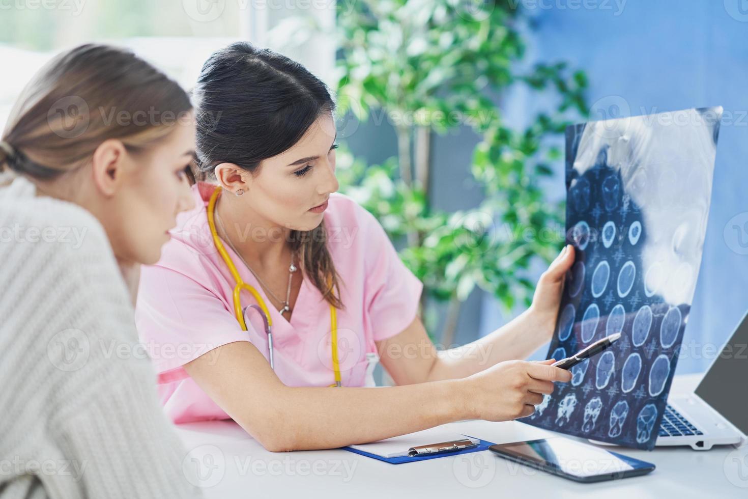 Doctor explaining diagnosis to her female patient photo