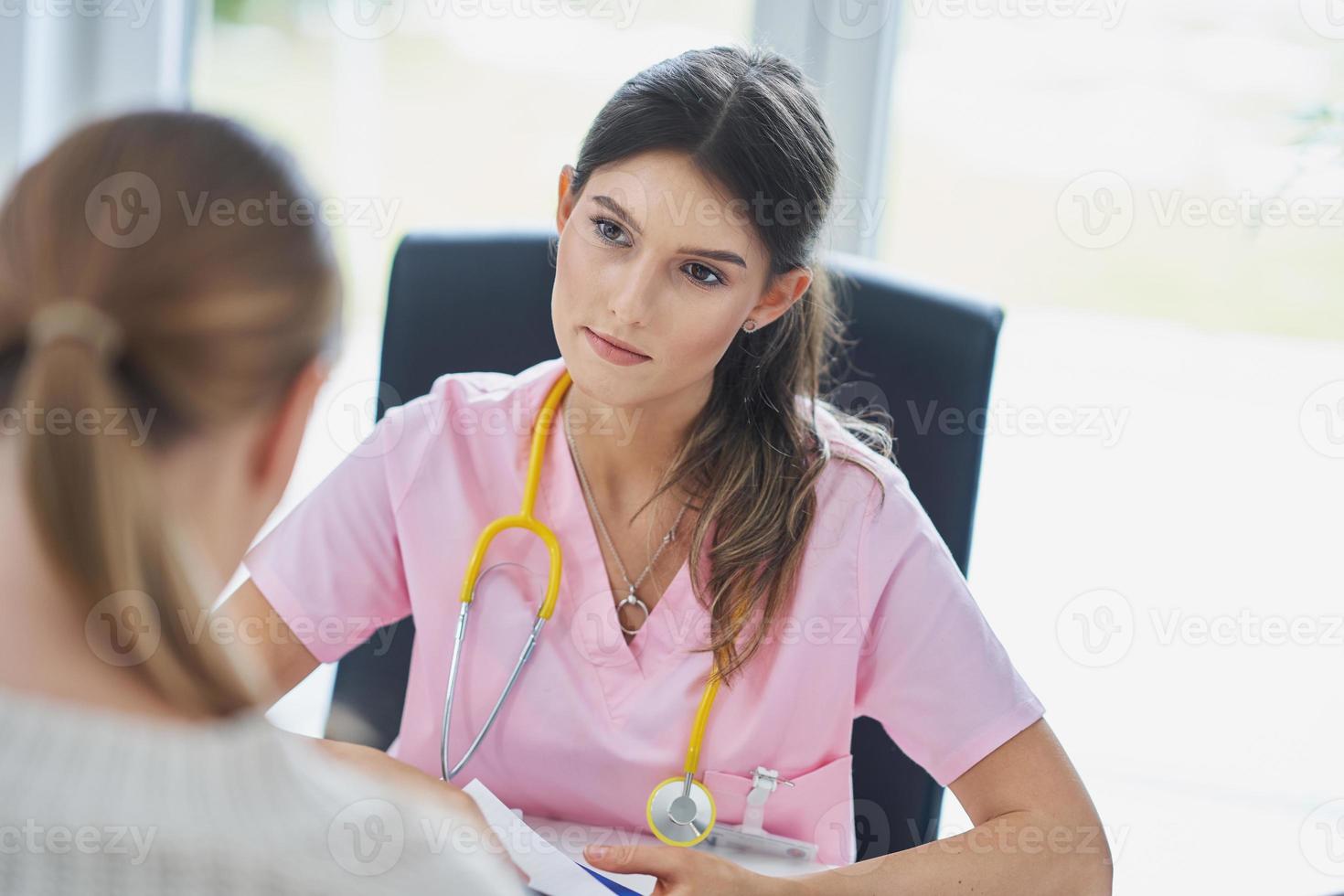 Doctor explaining diagnosis to her female patient photo