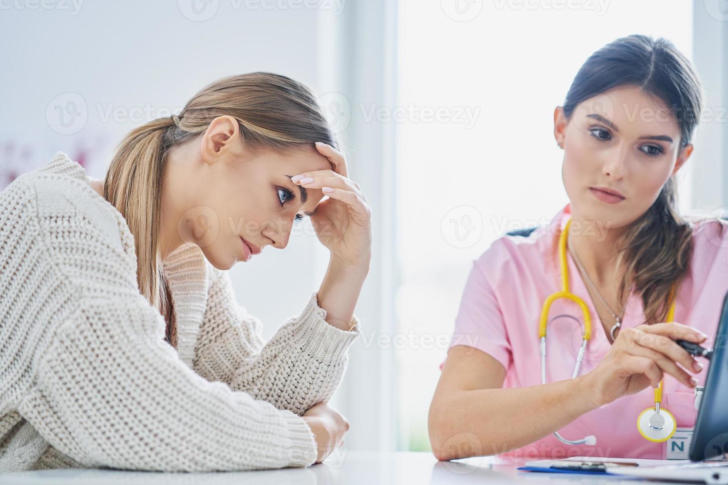 Doctor explaining diagnosis to her female patient photo