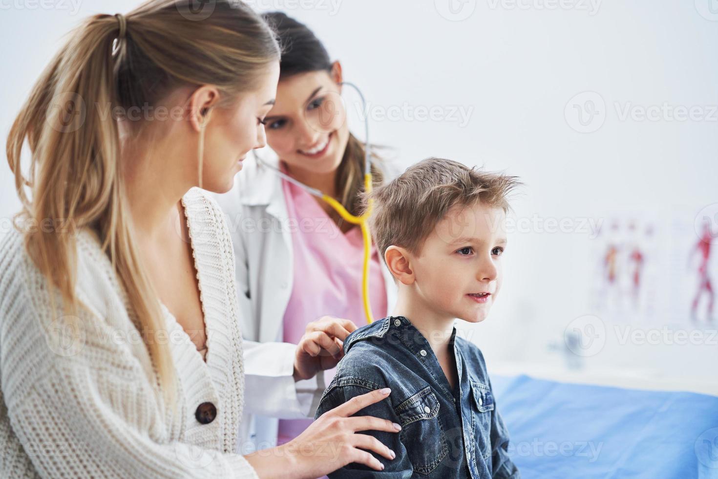 Little boy having medical examination by pediatrician photo