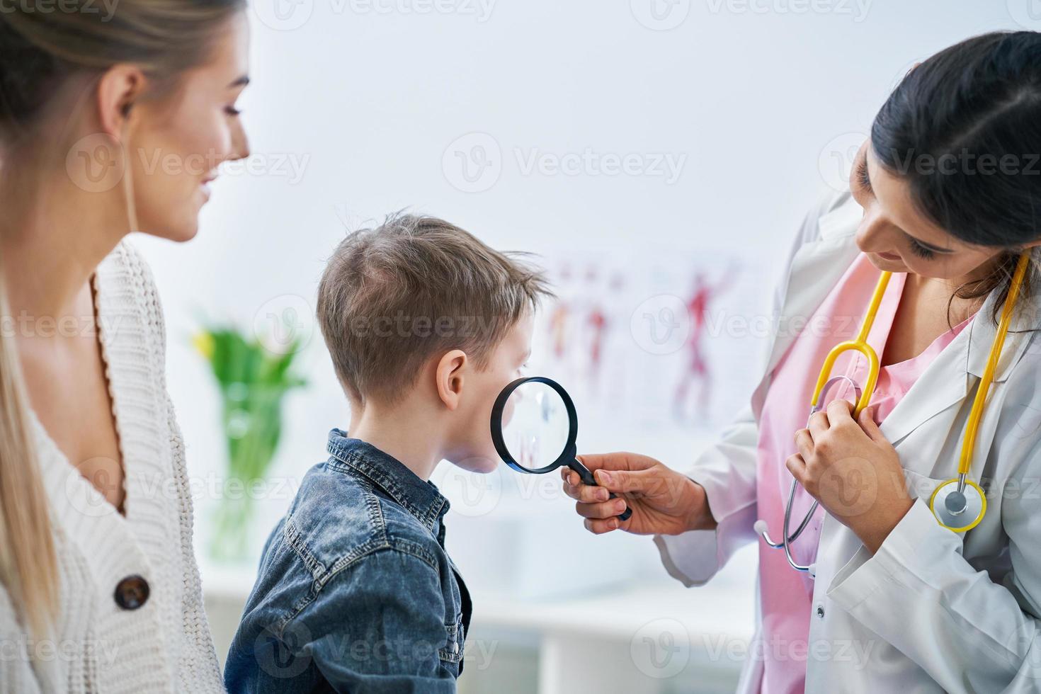 niño pequeño que tiene un examen médico por un dermatólogo foto