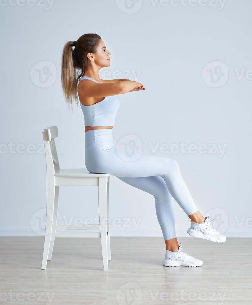 Adult beautiful woman working out over light background photo