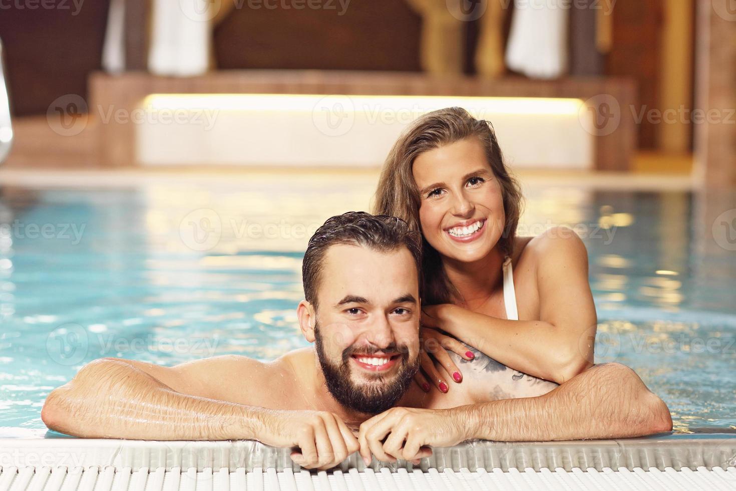 Happy couple relaxing in pool spa photo