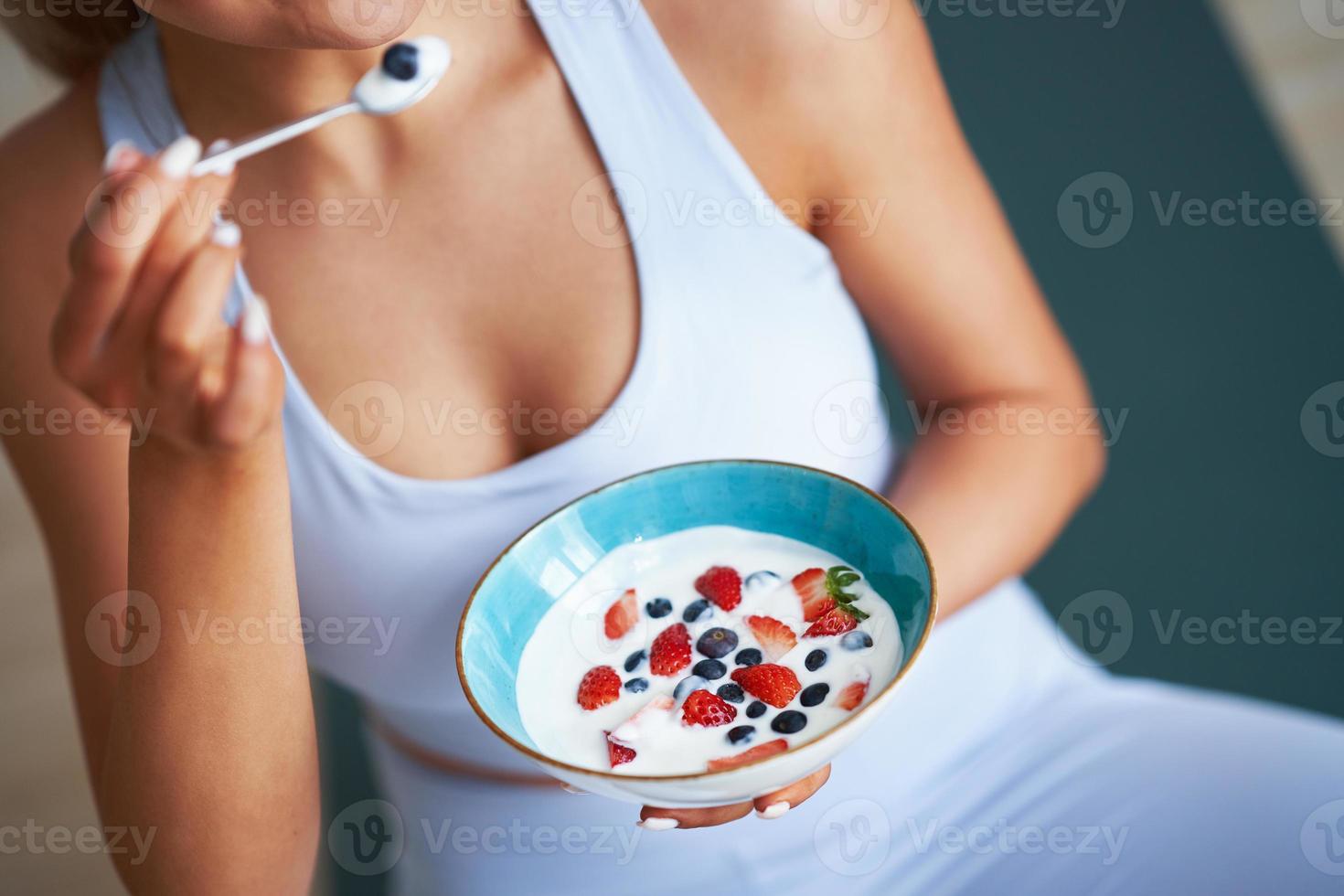 retrato de una hermosa mujer hispana comiendo yogur promoviendo un estilo de vida saludable foto