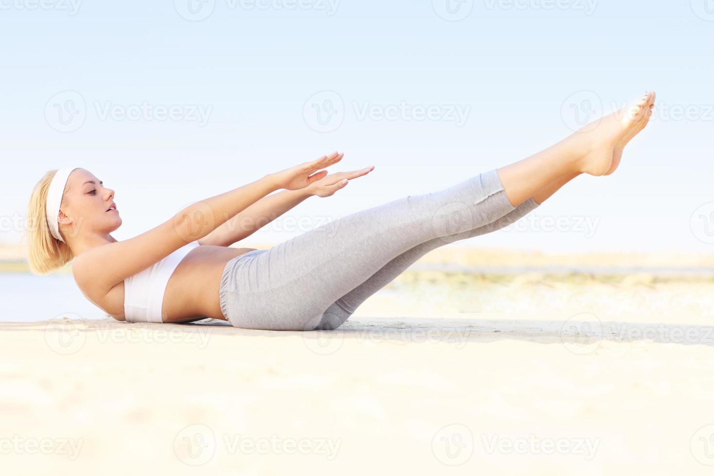 mujer joven haciendo ejercicio en la playa foto