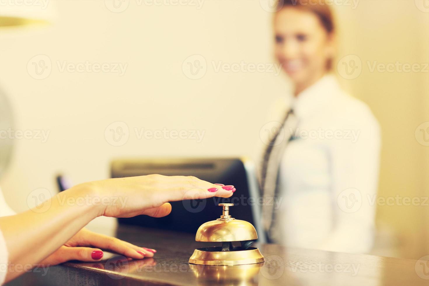 invitado usando el timbre de recepción en el vestíbulo foto