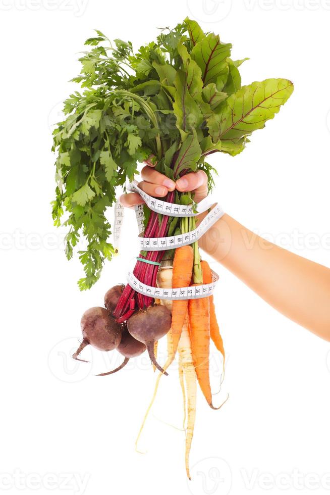 cinta métrica de verduras y mano foto