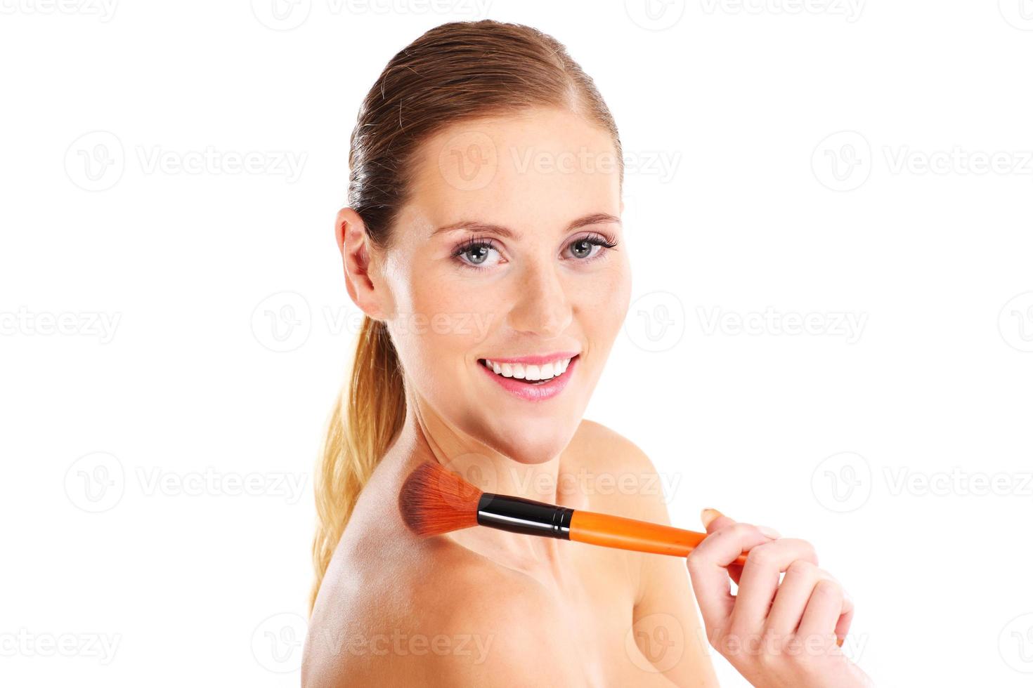 Portrait of a sensual woman with makeup brush photo