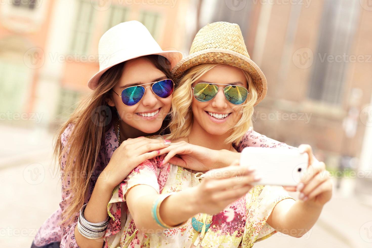 Two happy girl friends taking selfie photo