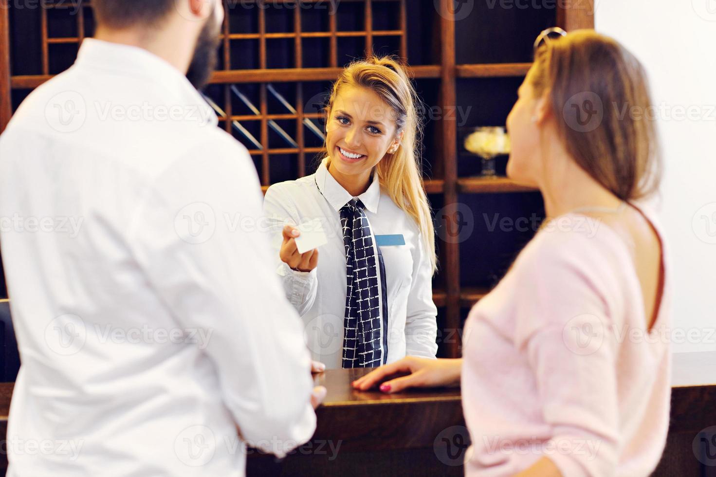 Couple at reception desk in hotel photo