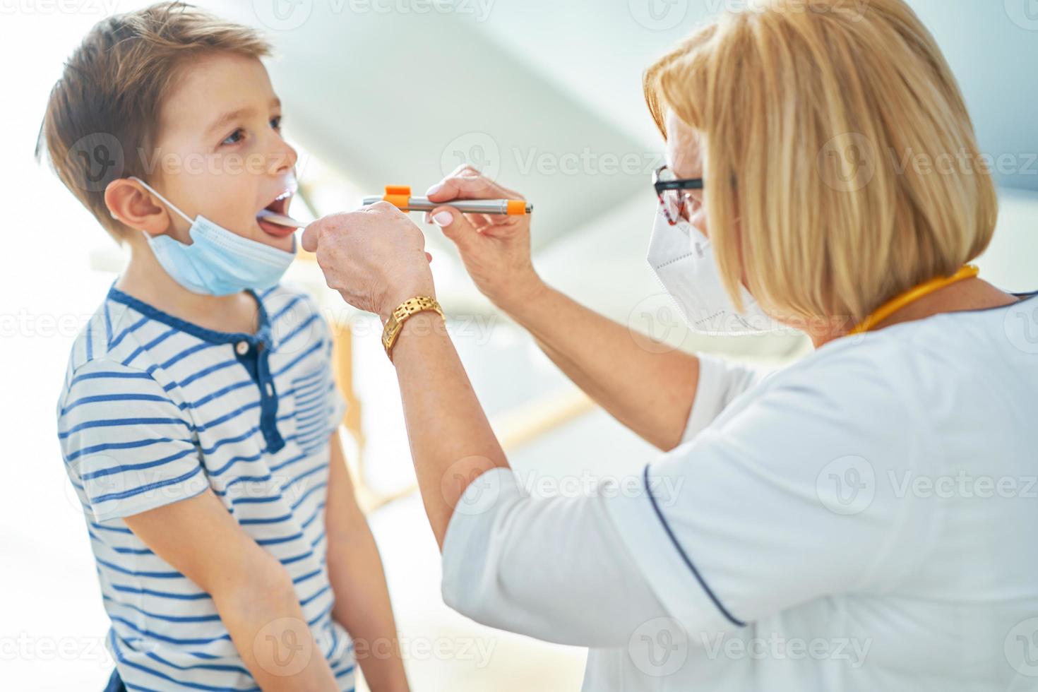 Pediatrician doctor examining little kids in clinic photo