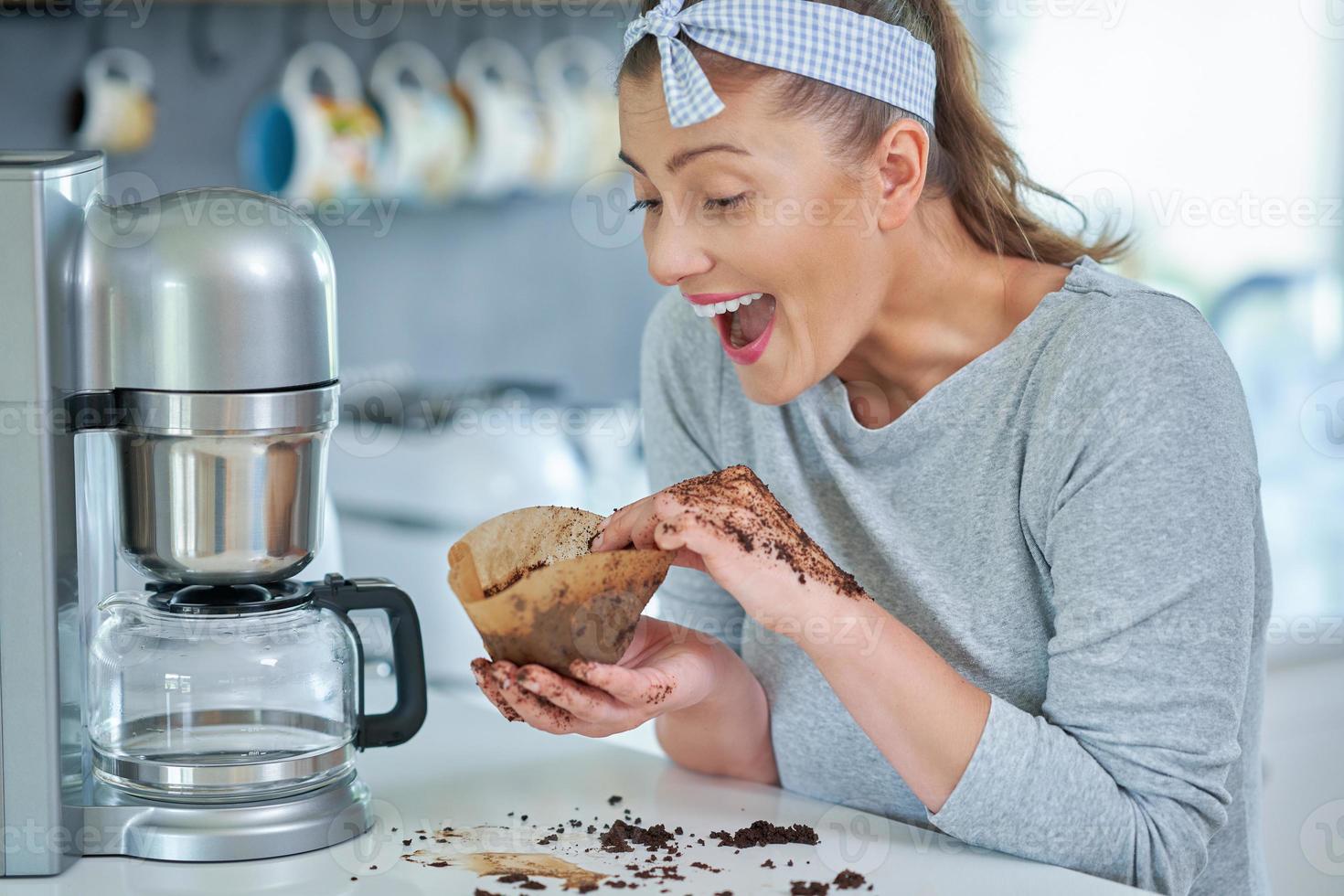 Young woman with coffee grounds use it for peeling photo