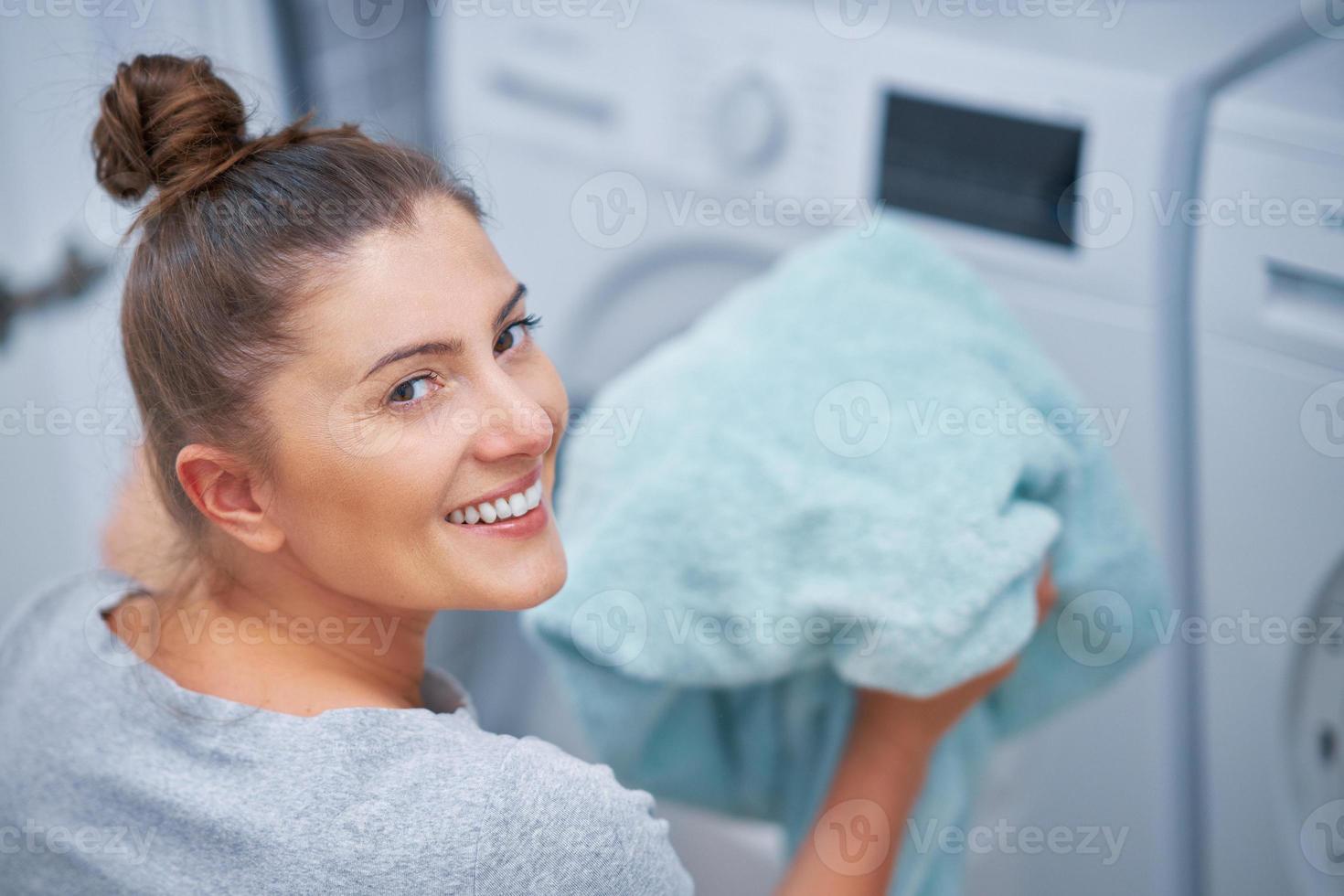 Picture of young woman making laundry work photo