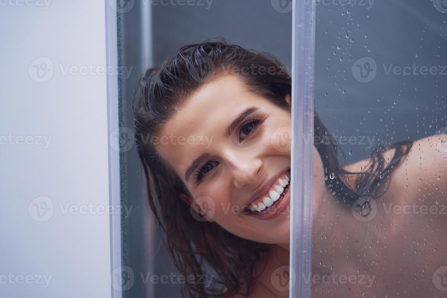 Adult woman under the shower in bathroom photo