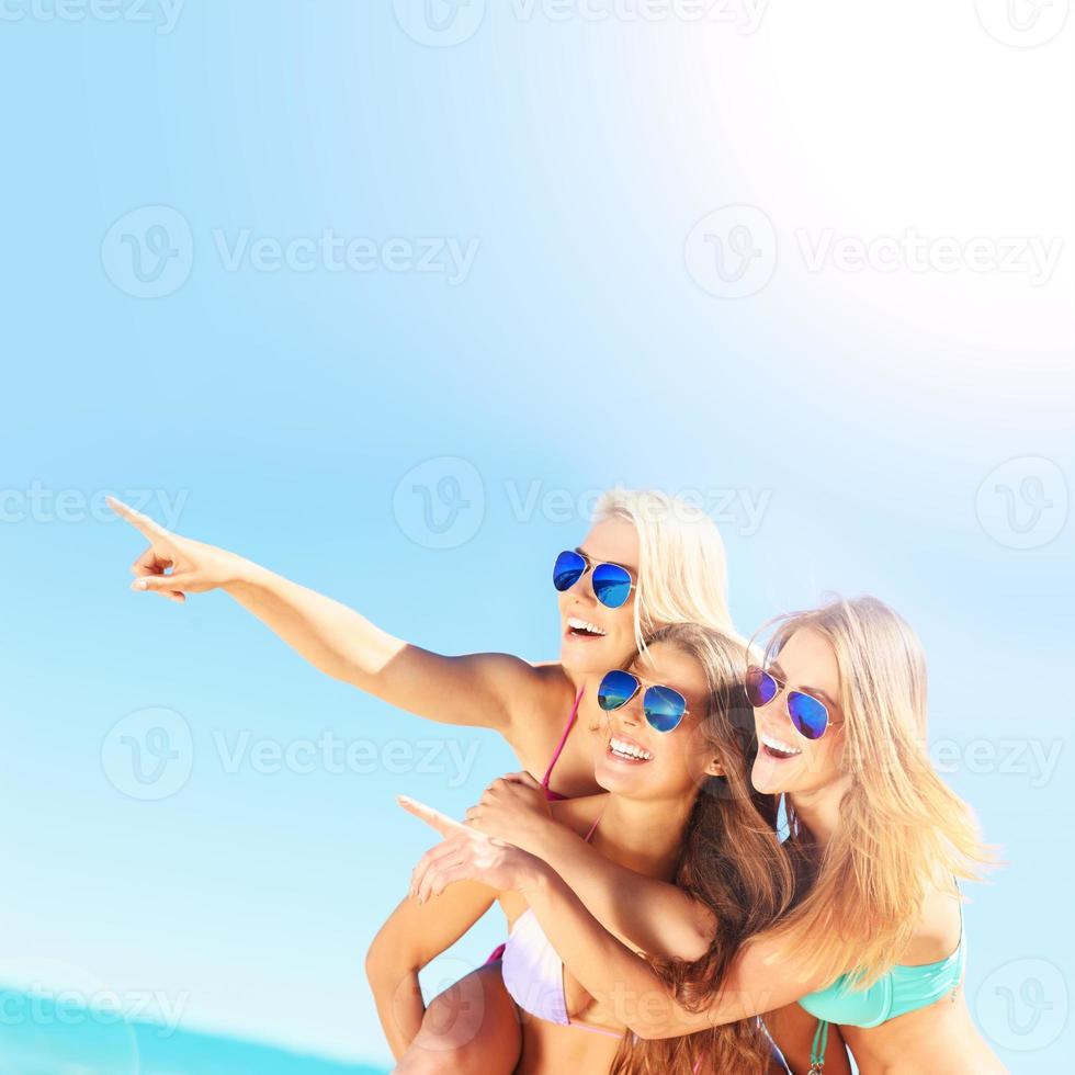 Group of women pointing at something on the beach photo