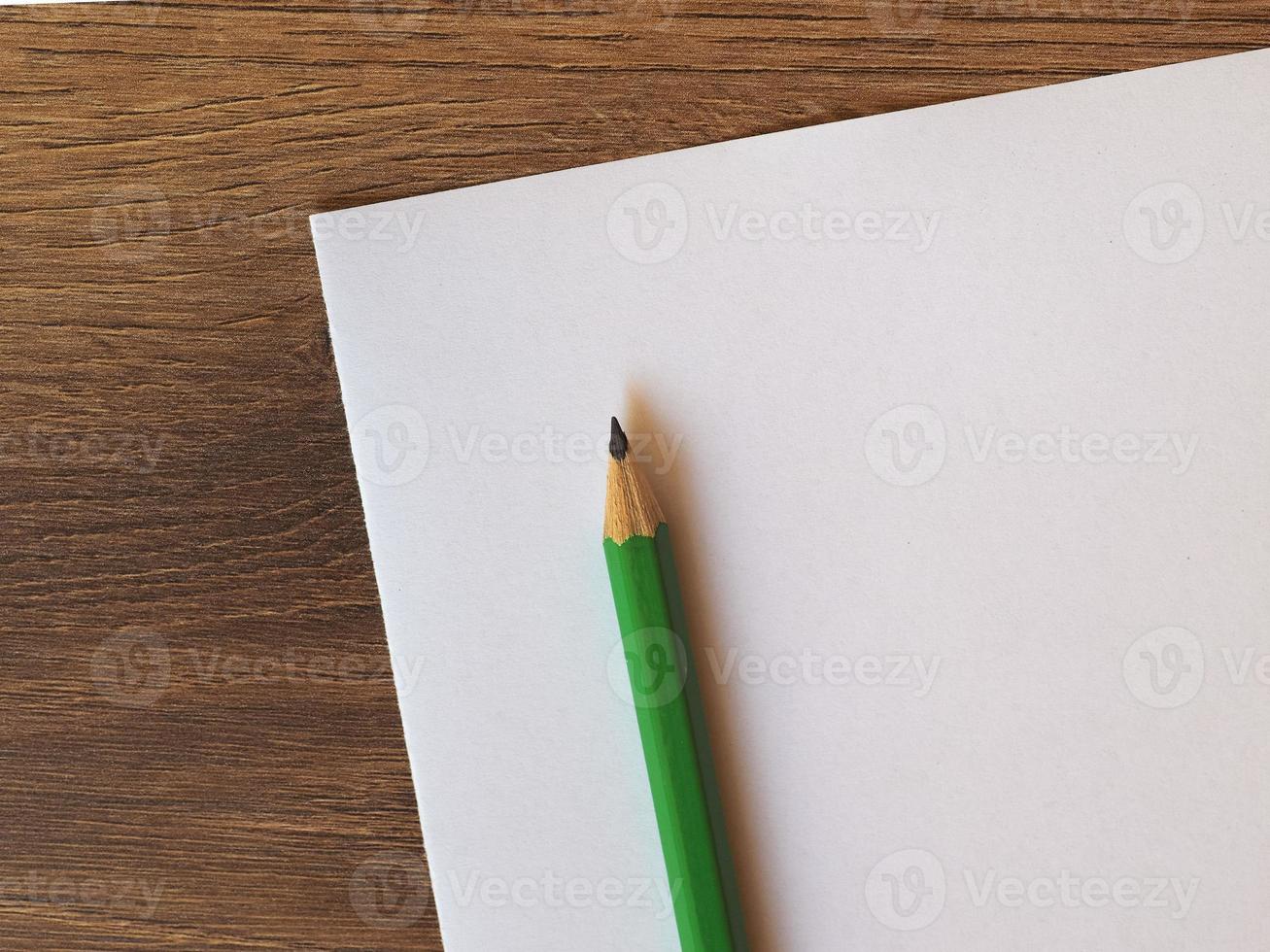 green pencil on paper sheet desk photo