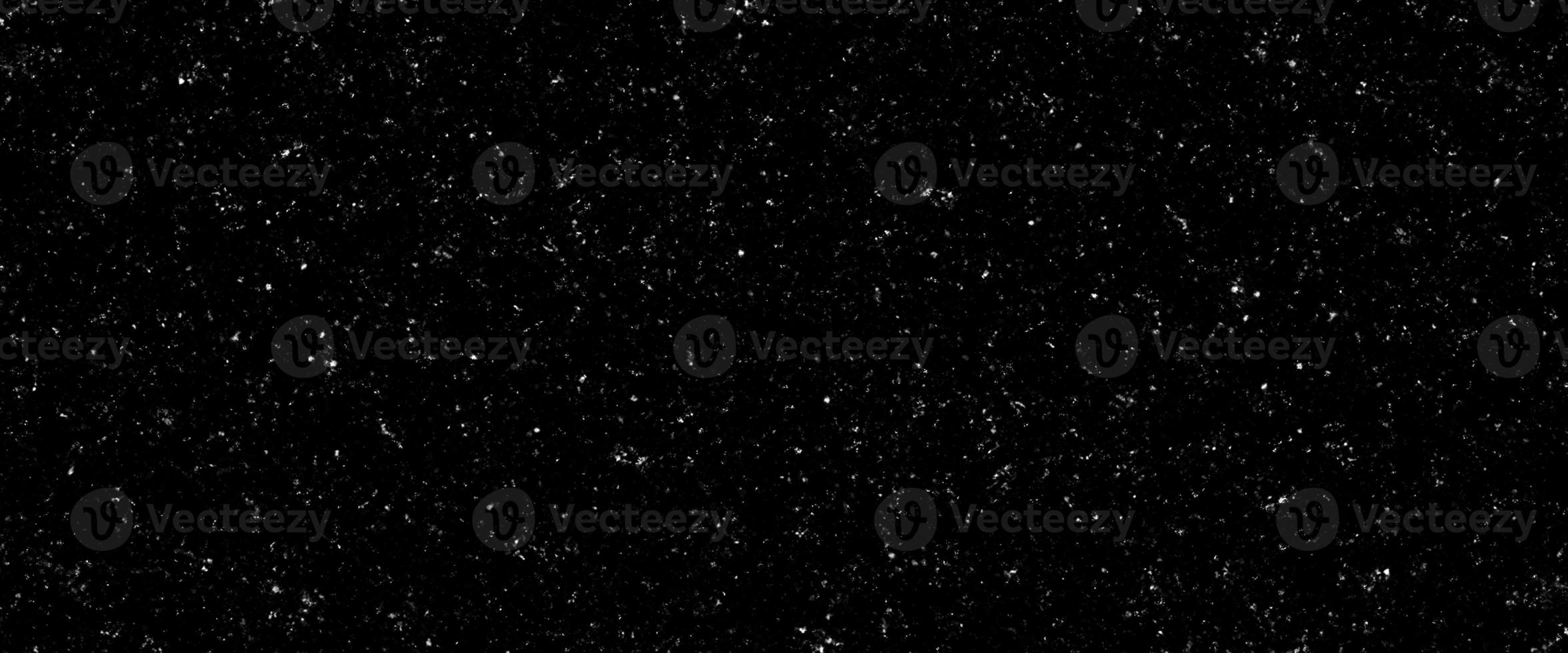 Falling snow flakes, Flying dust particles on a black background. Abstract winter background. Winter landscape with falling shining beautiful snow. photo