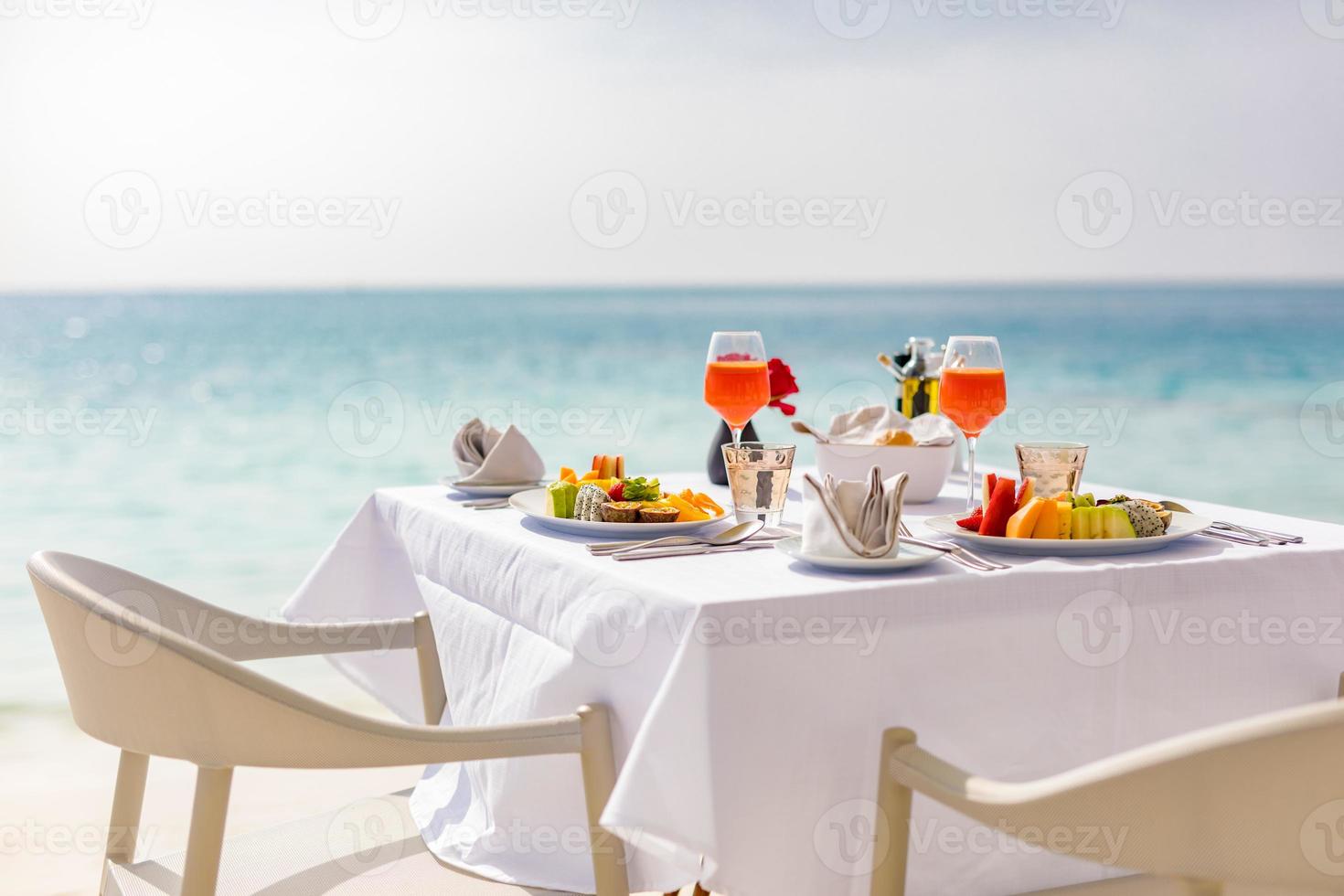 mesa de desayuno de lujo hermoso fondo de cielo de mar tropical. idílica mañana romántica amor parejas tiempo en vacaciones de verano. concepto de vacaciones románticas de luna de miel. viajes y estilo de vida, restaurantes de destino foto