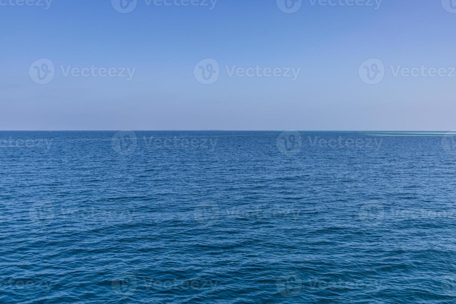 Blue ocean waves endless horizon. Blue sea surface and clear blue sky photo