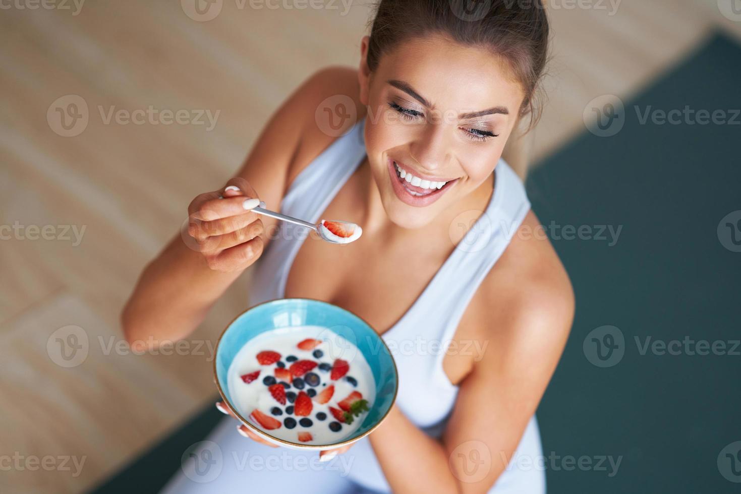 retrato de una hermosa mujer hispana comiendo yogur promoviendo un estilo de vida saludable foto