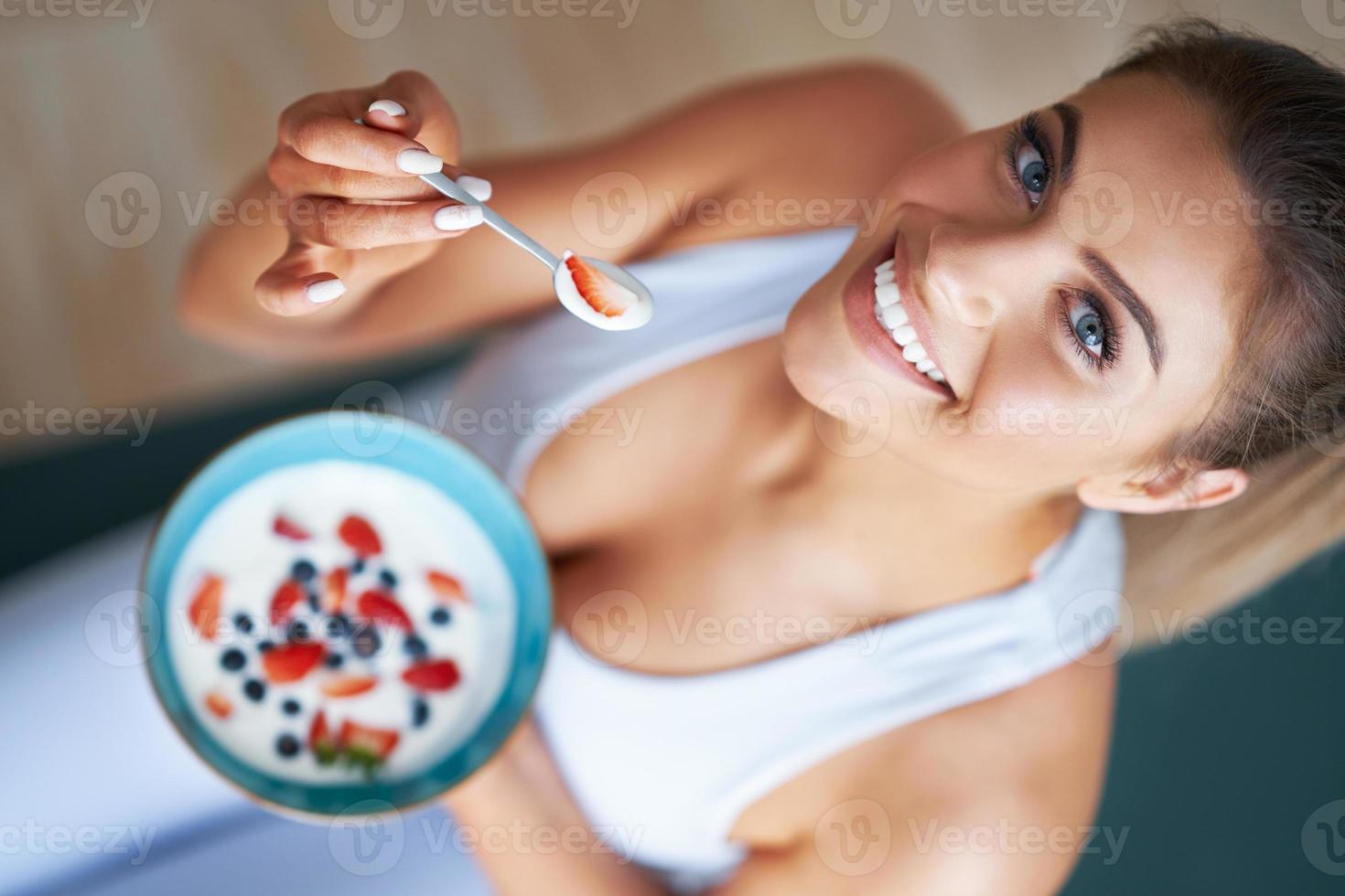 retrato de una hermosa mujer hispana comiendo yogur promoviendo un estilo de vida saludable foto