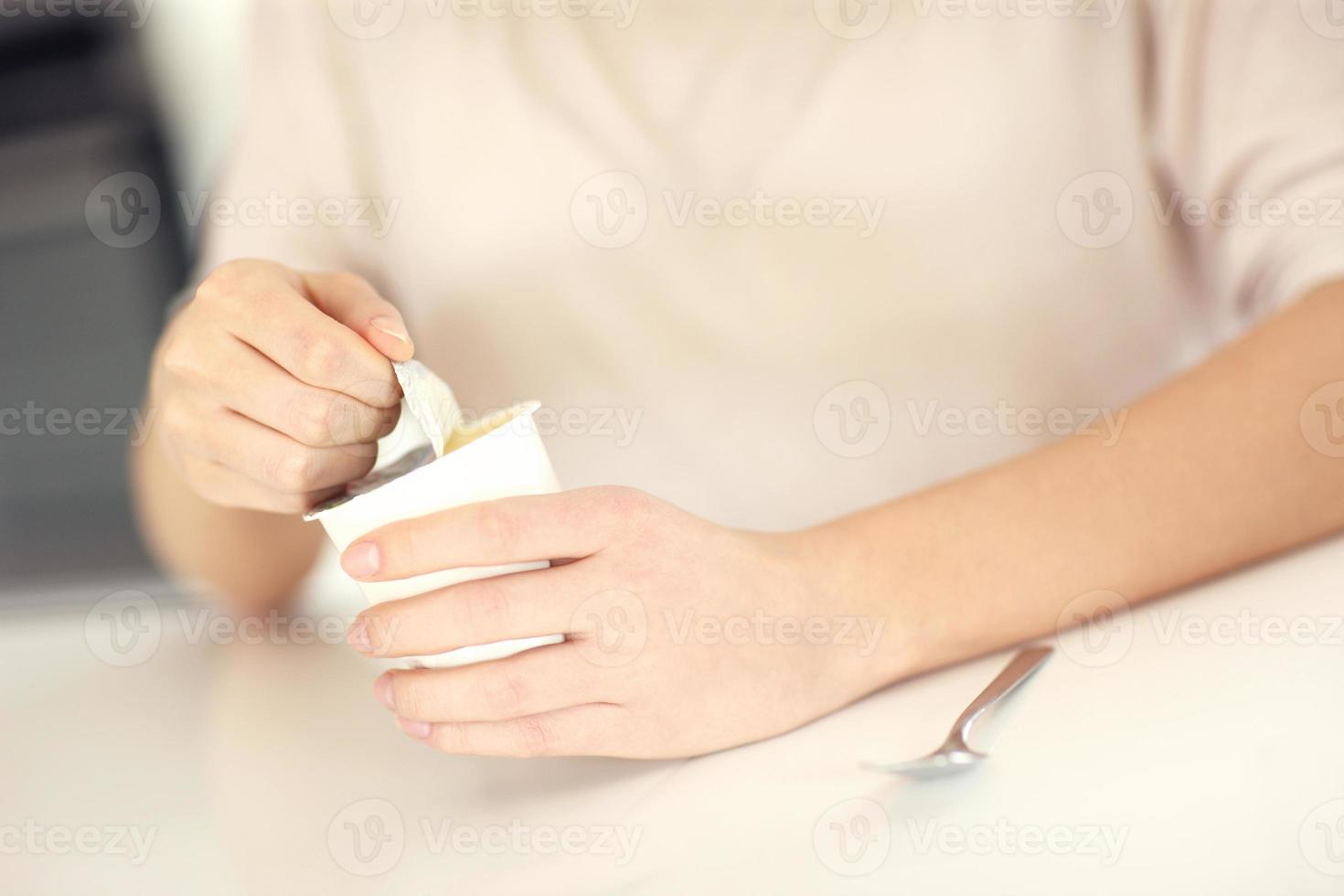 Woman opening yogurt photo