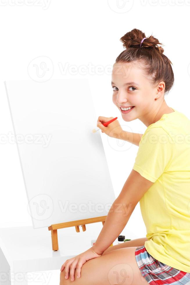 Young girl painting on an easel photo