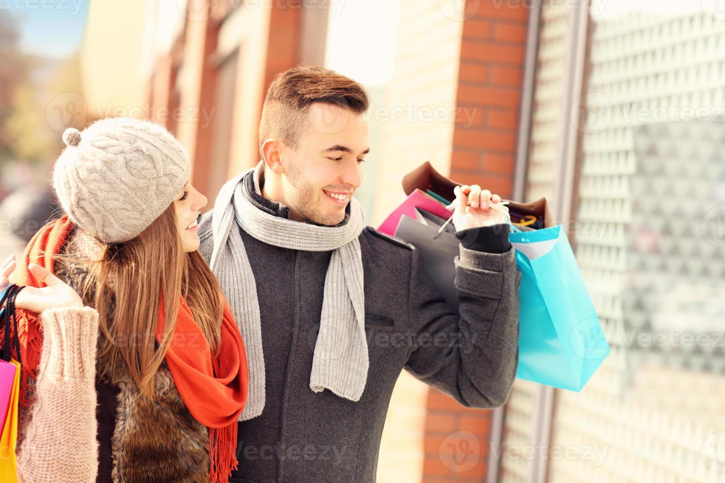 Happy couple window shopping in the city photo