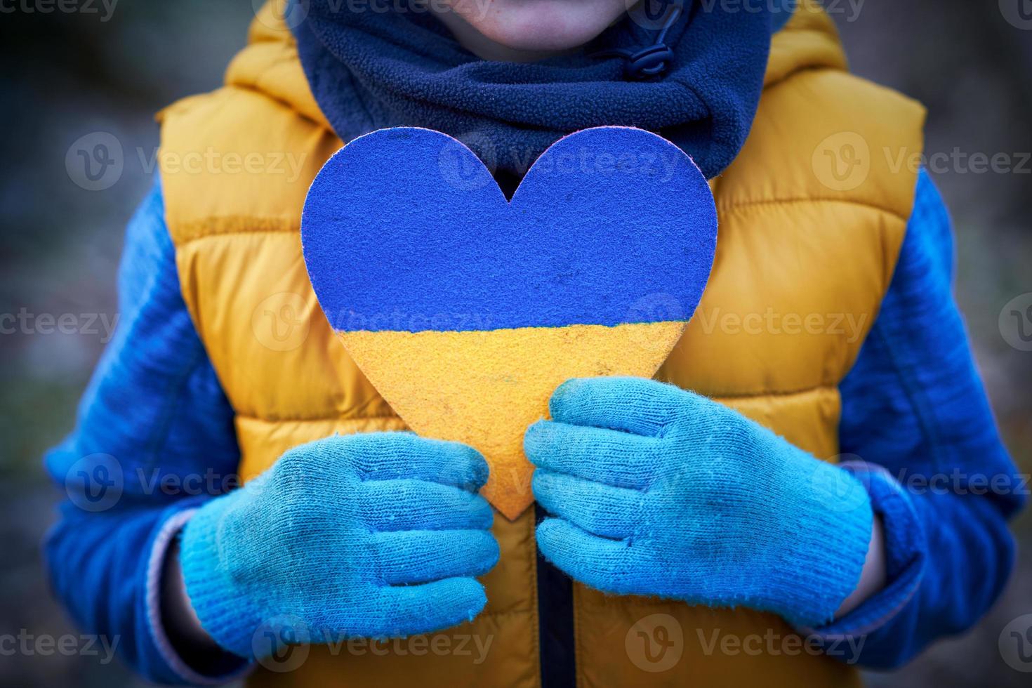 Picture of a child with a lot of love and peaceful message holding heart photo