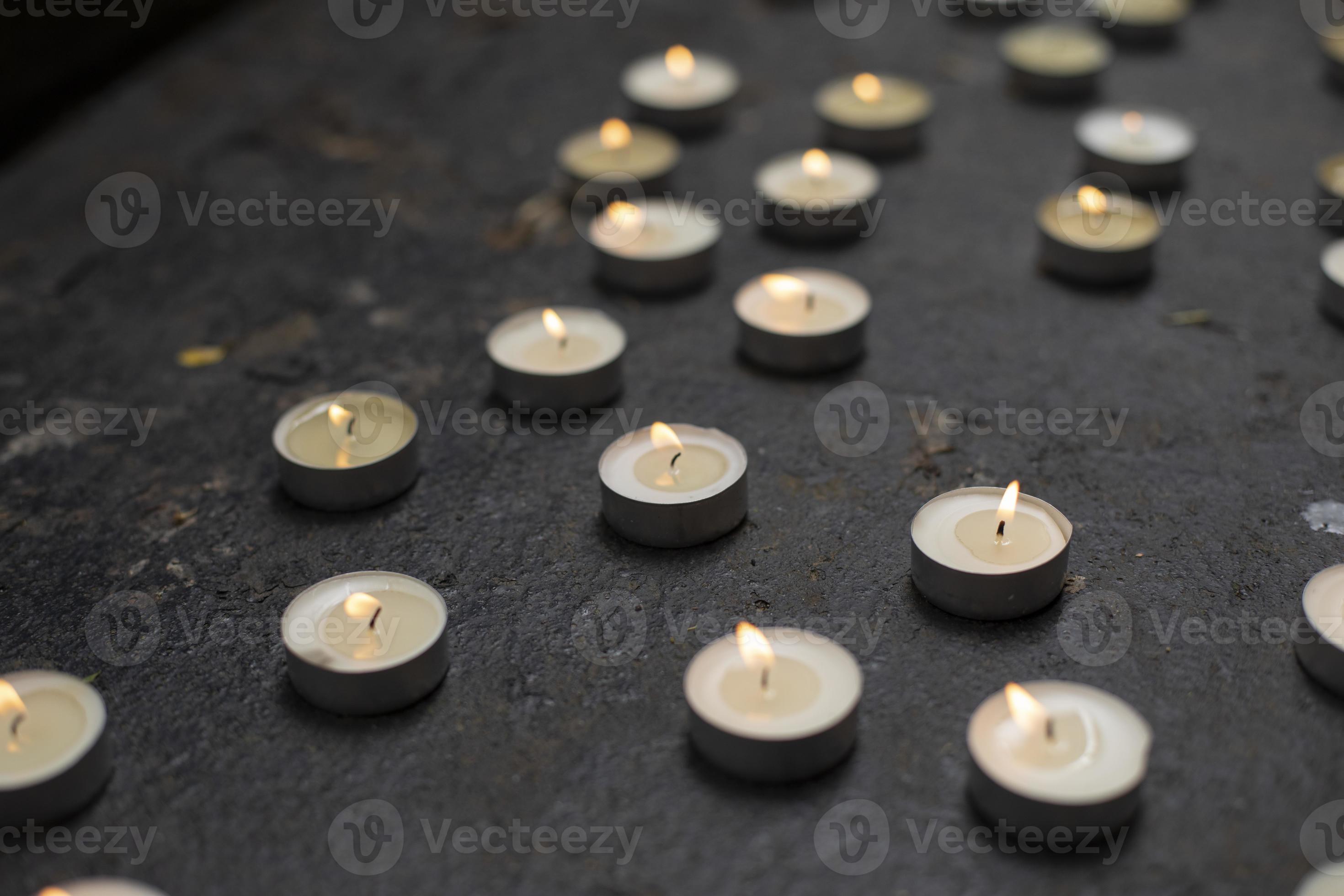 Lots of round candles on grave. Details of memorial ceremony. Candles