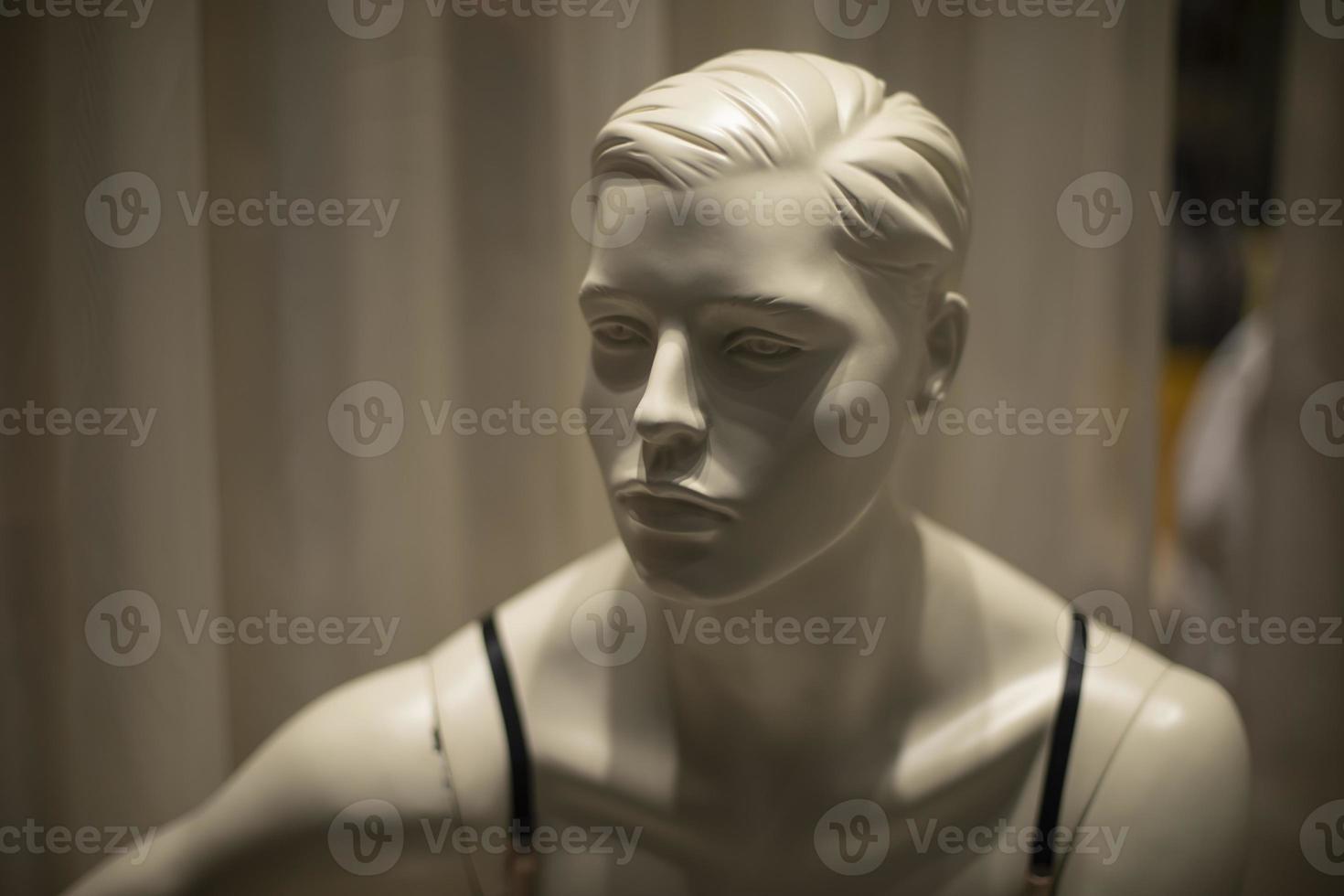 Mannequin face. White figure made of plastic. Details of showcase of clothing salon. photo