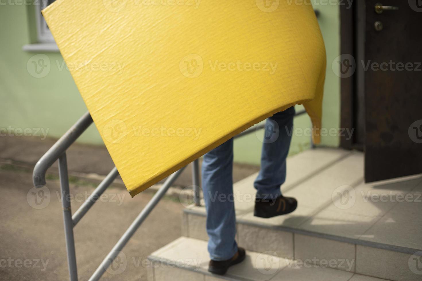 Cleaning of sports equipment. Yellow mat in hand. Loader carries thing. photo