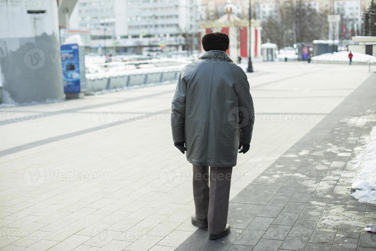 Man in poor clothes. Life of old man in city. photo